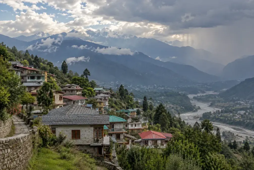 Illustrative mountain settlement and valley beneath cloud-covered peaks.